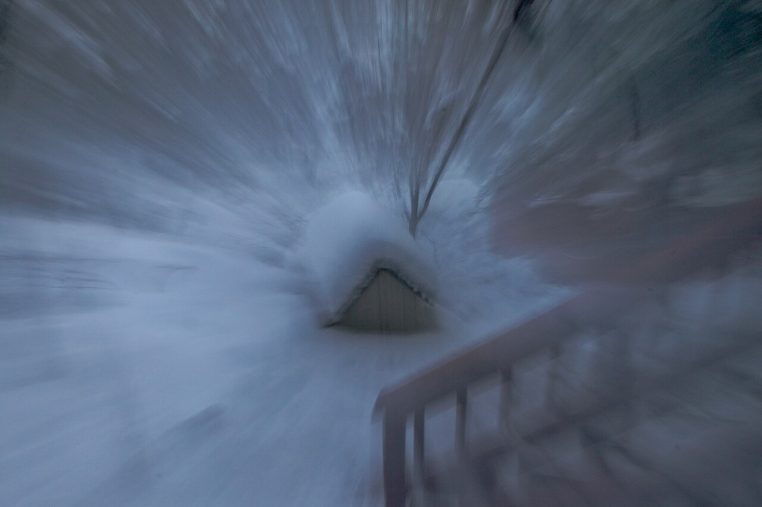 Niche de chien recouverte de neige, scène hivernale floue avec effet de mouvement, ambiance froide et sombre.