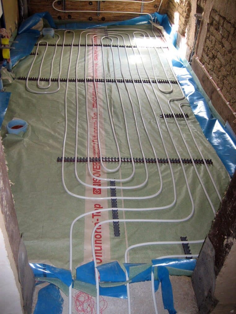 Gros plan sur des tubes de chauffage au sol fixés avant installation du revêtement