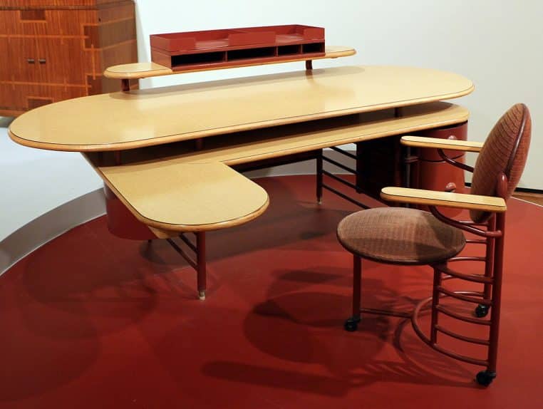 Bureau et chaise de travail au design rétro, photographiés dans un musée.