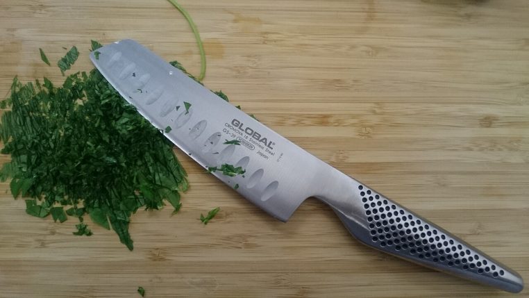 Herbes vertes finement ciselées sur une planche en bois