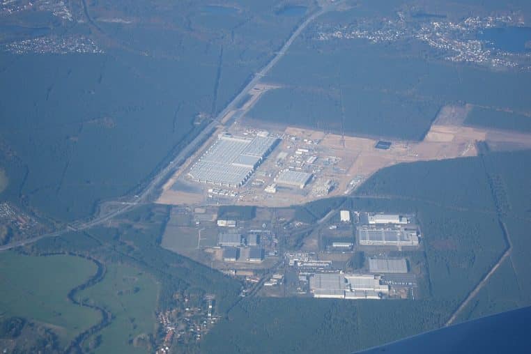 Vue aérienne de la Gigafactory Berlin-Brandenburg à Grünheide, avec les bâtiments industriels et la forêt environnante.