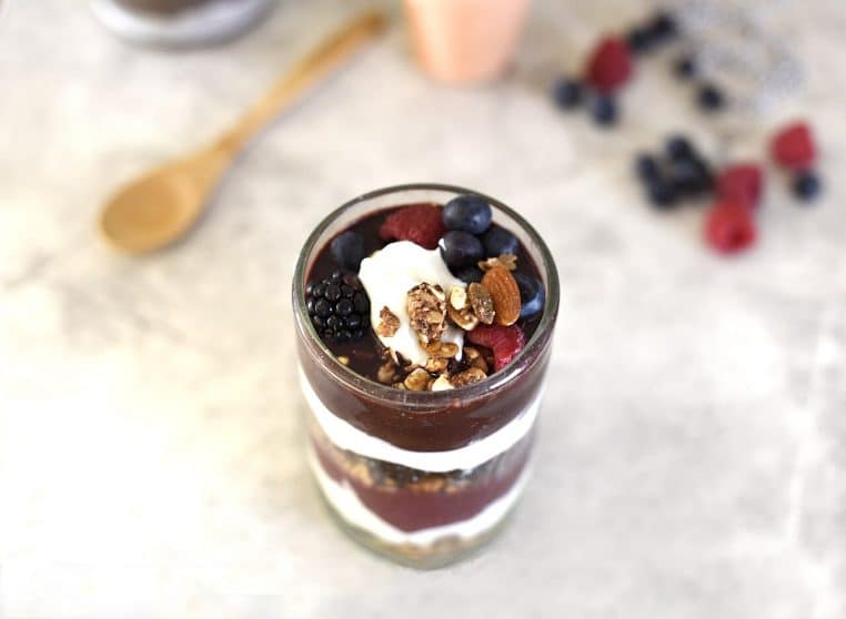 Verrine dessert préparée à l’avance avec fruits rouges et granola, posée sur un plan clair, style meal prep.