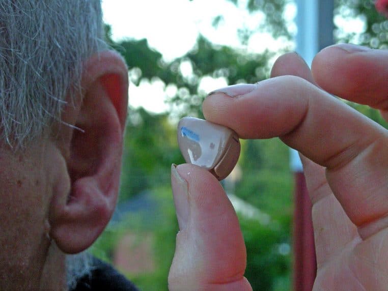 Gros plan d’un appareil auditif posé, destiné à être placé derrière l’oreille.