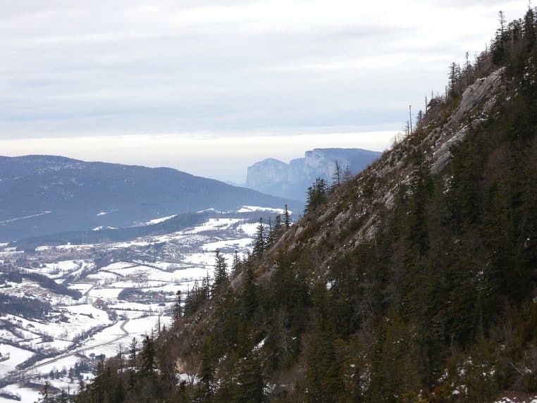 Randonnée dans la neige à Saint-Agnan-en-Vercors, traces sur le chemin et plateau blanc bordé d’arbres.