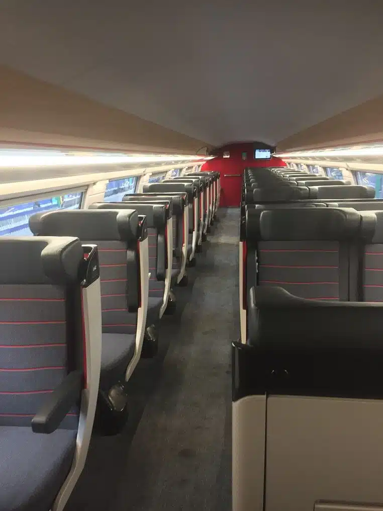 Rangées de sièges de première classe à bord d’un TGV Duplex, avec tablettes et prises.