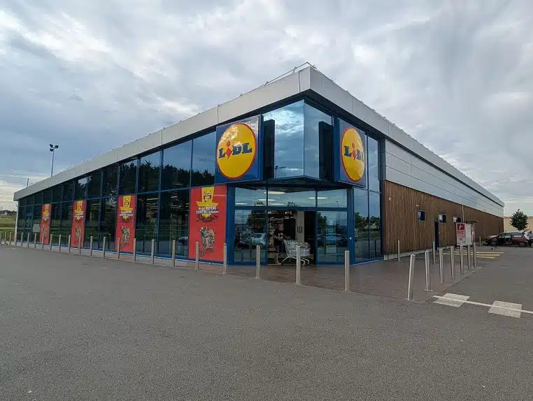Façade d’un magasin Lidl en France, entrée et enseigne visibles, photo extérieure en journée, contexte grande distribution.