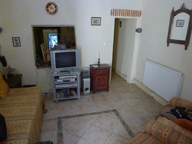 Salon avec un radiateur mural visible, illustration d’un chauffage central dans une pièce de vie occupée.