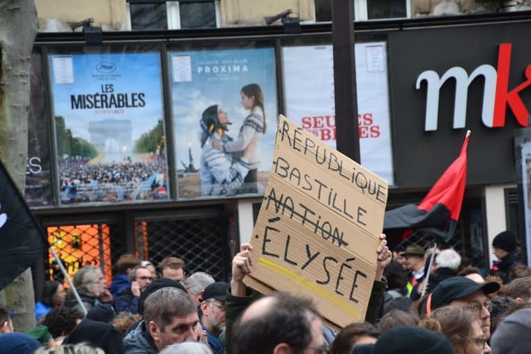 Grande manifestation à Paris contre une réforme des retraites, foule dense avec pancartes.