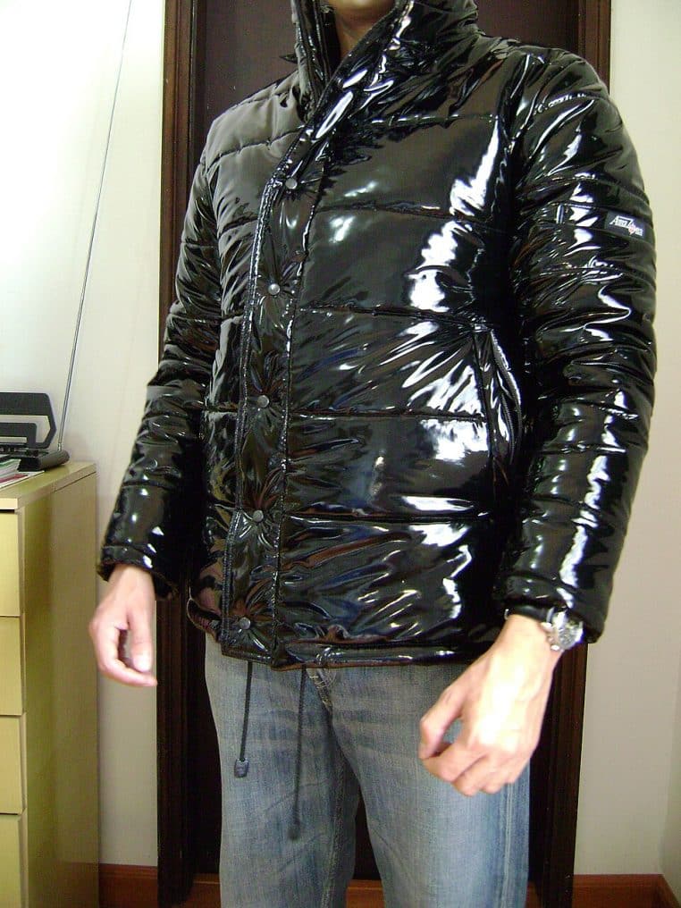 Doudoune matelassée noire photographiée de face, posée à plat, avec fermeture zippée apparente.