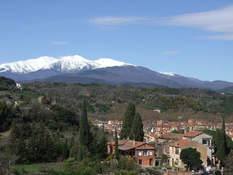 Paysage près de Céret avec reliefs du Canigou en arrière-plan, ciel dégagé et végétation méditerranéenne.