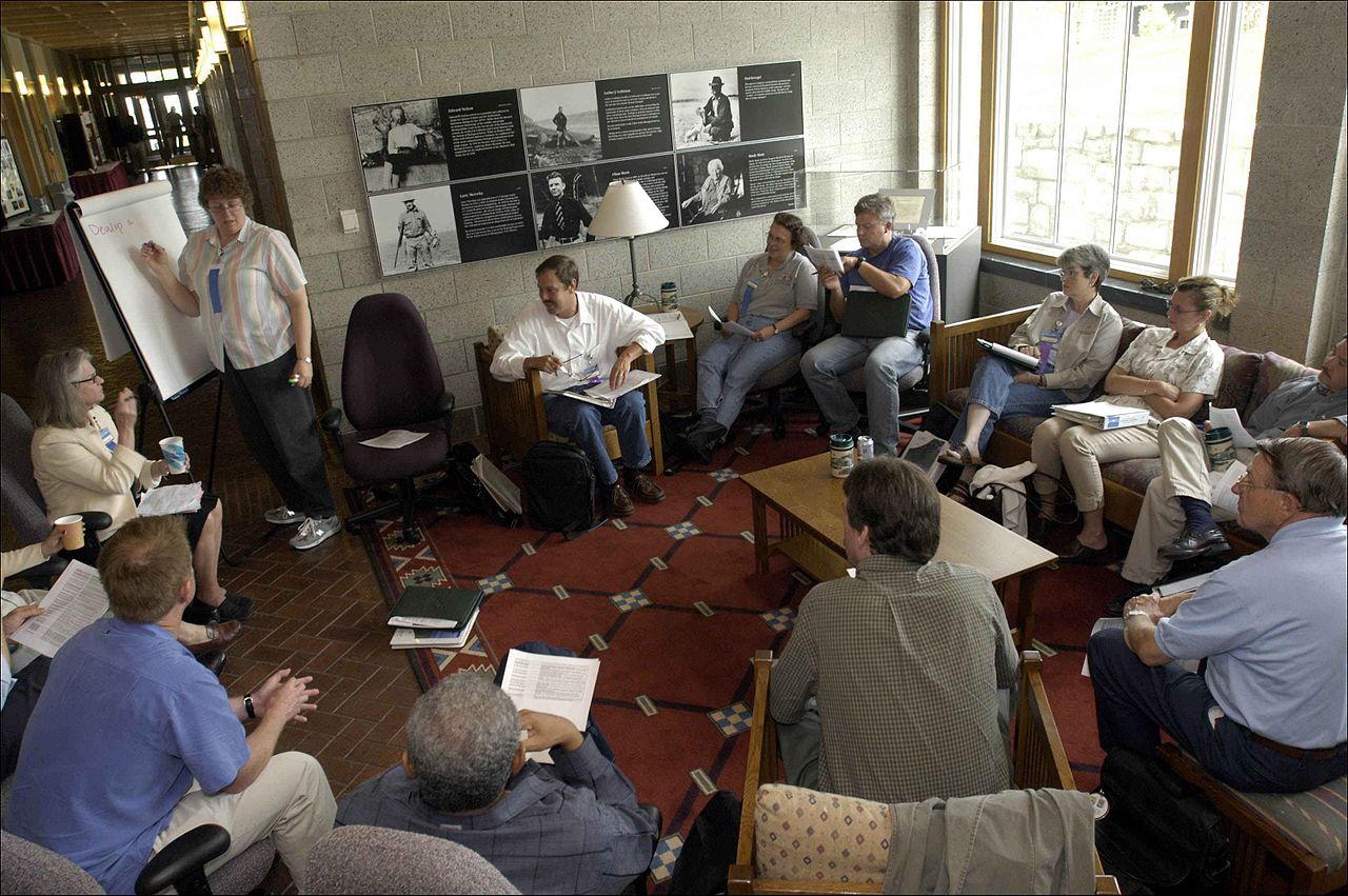 Petit groupe en discussion autour d'une table lors d'une réunion.