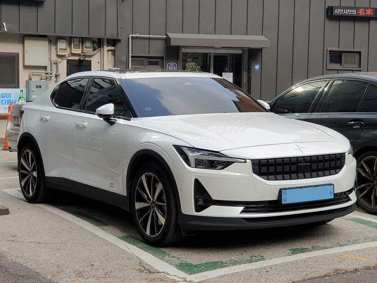 Polestar 2 grise posée sur une route enneigée, scène hivernale nette, voiture électrique en conditions de grand froid.