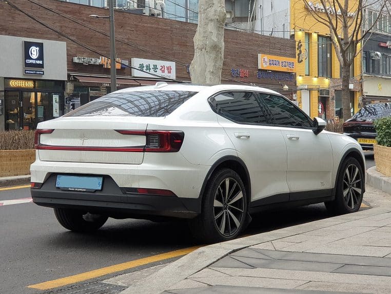 Polestar 2 photographiée sur fond enneigé, vue latérale sur route froide, ambiance d’hiver, voiture électrique compacte.