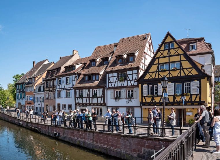 Maisons à colombages le long du quai de la Poissonnerie à Colmar, au bord de la Lauch, vues en perspective.