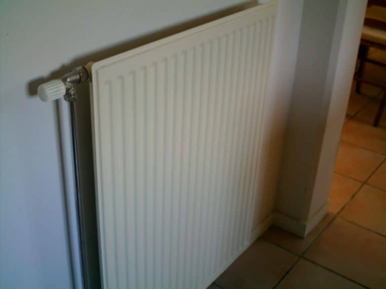 Radiateur mural blanc dans une pièce, photographié de face.