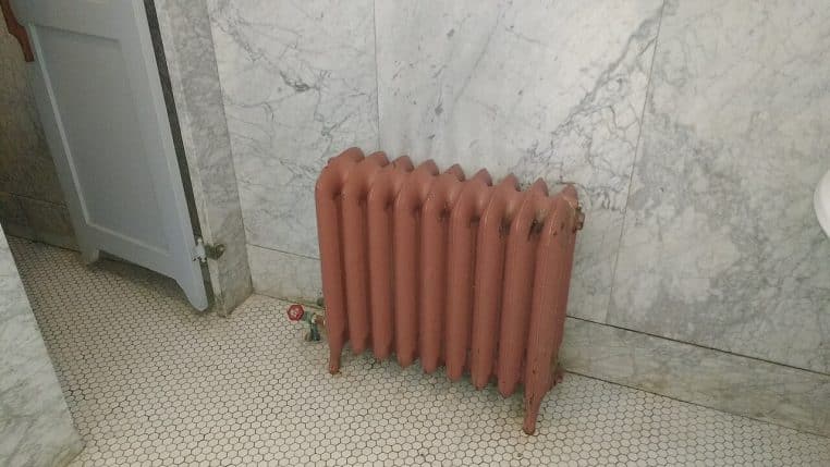 Radiateur installé dans une salle de bain carrelée, exemple de chauffage ponctuel dans une pièce humide.