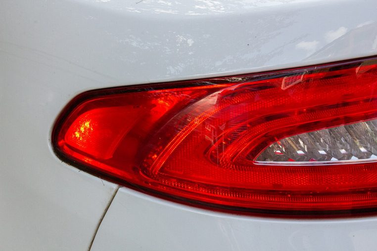 Gros plan sur des feux stop rouges d’une voiture, éclairage intense.