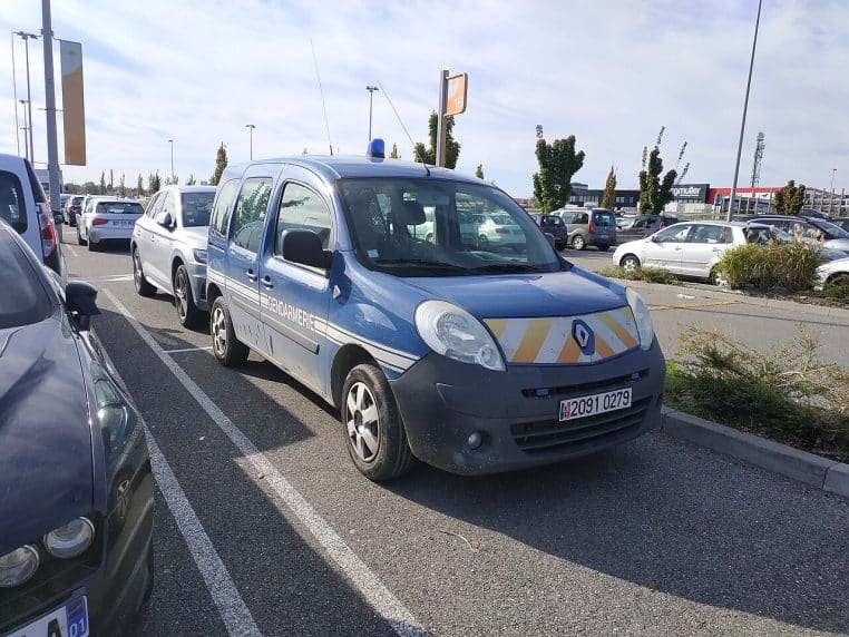 Véhicule de la gendarmerie nationale stationné sur un parking, marquages visibles, photo horizontale.