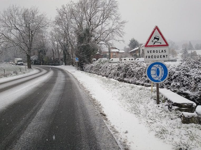Route enneigée en Haute-Savoie avec panneaux « chaussée glissante », « verglas fréquent » et chaînes obligatoires