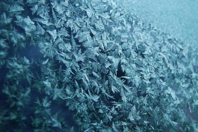 Pare-brise recouvert de cristaux de givre au petit matin.