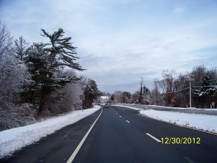 Route dégagée bordée de neige, traces de passage et paysage rural froid, conditions typiques d’un matin de janvier