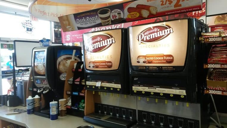 Distributeurs de café en libre-service, grands écrans et boutons, illustration des boissons chaudes et du rituel café