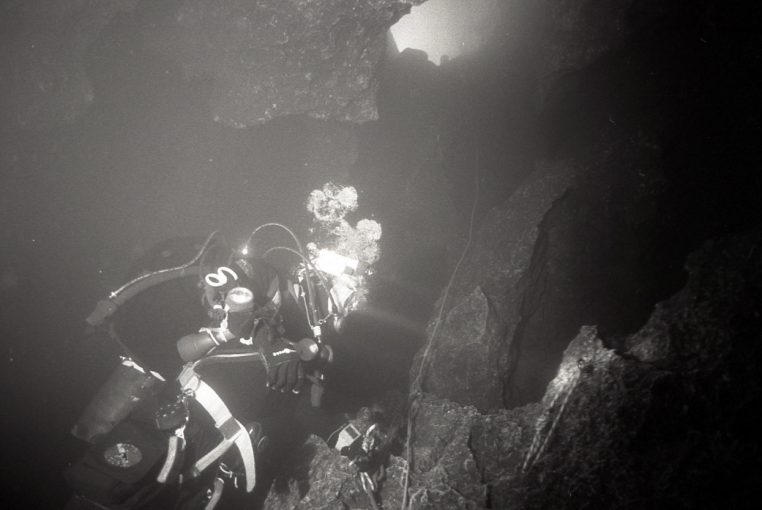 Plongeur spéléo au départ d’une galerie de Font Estramar, équipé pour la progression souterraine.