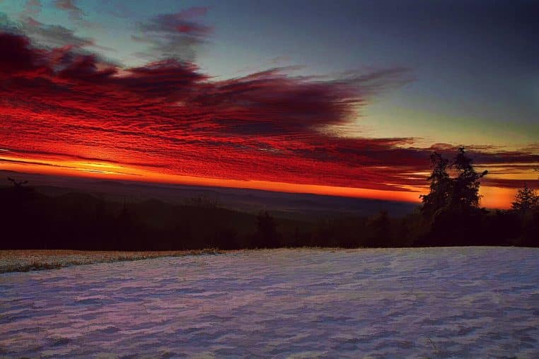 Lever de soleil sur un paysage enneigé, symbolisant l’importance de la lumière matinale.