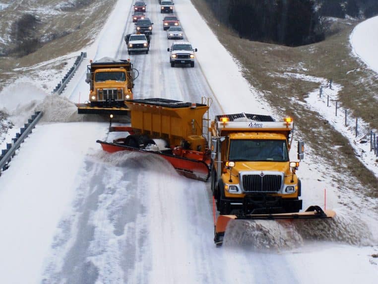 Camion TowPlow de déneigement sur une interstate rurale, chaussée froide et dépôt de neige sur les accotements