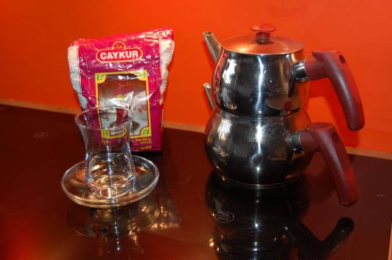 Théière posée sur une surface de cuisson noire, scène de cuisson simple avec récipient directement sur la plaque.