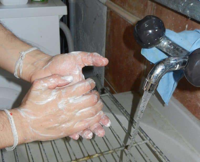 Lavage des mains au savon sous un robinet.
