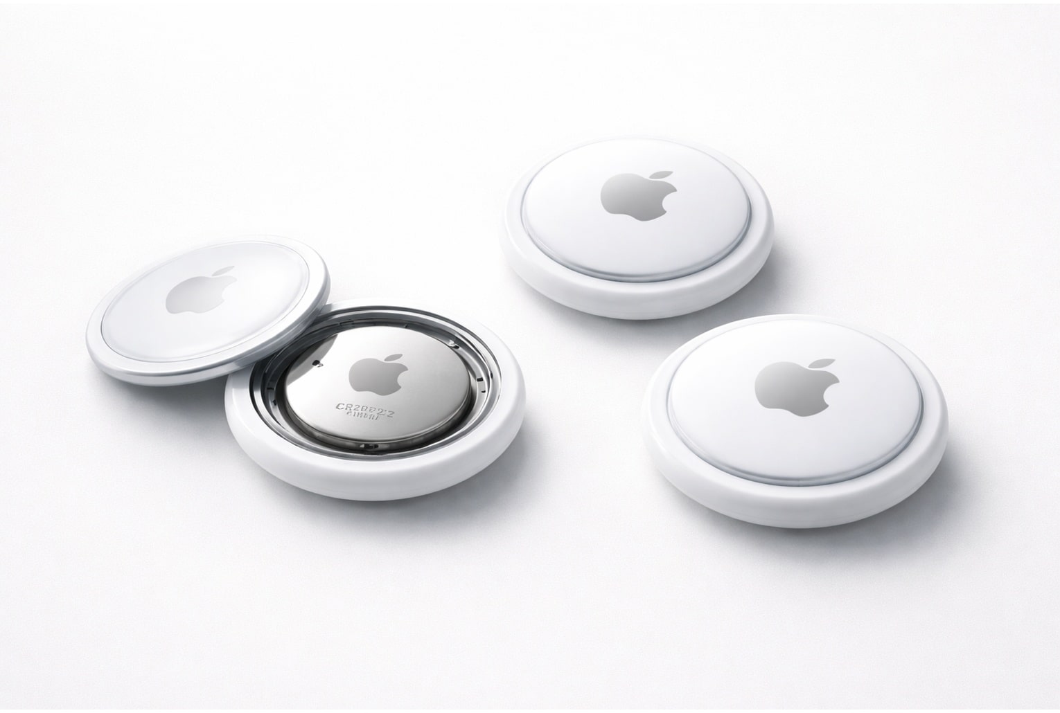 AirTag 2 posés sur fond blanc minimaliste, esthétique Apple