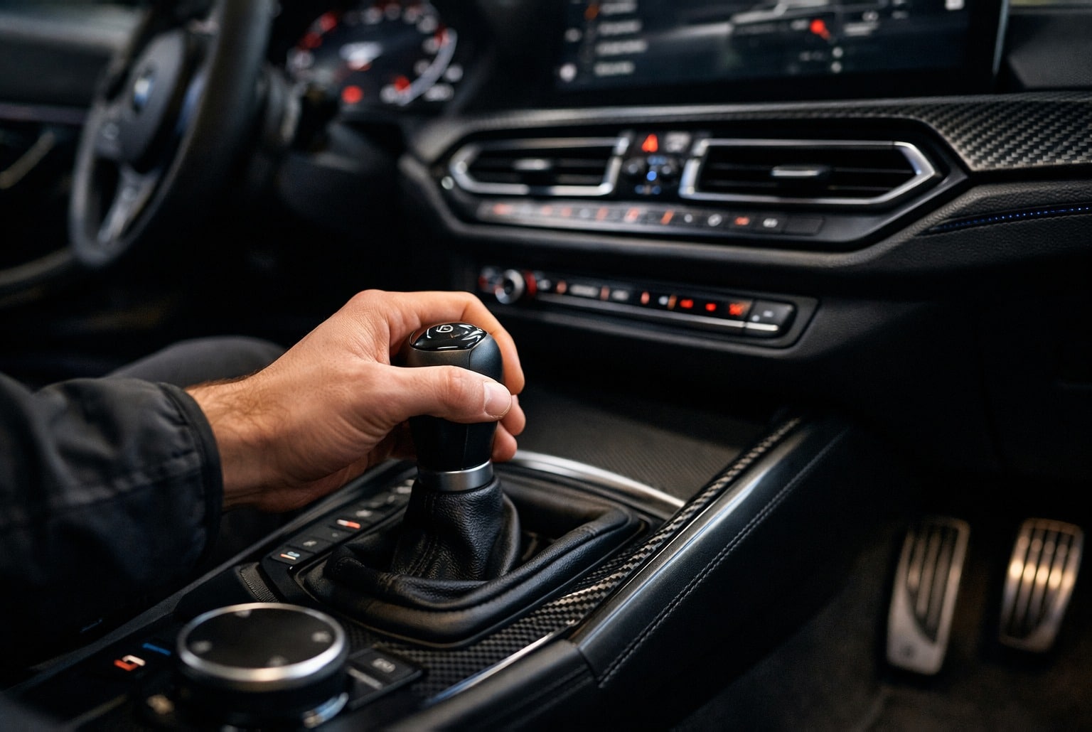Main sur le levier d’une sportive, pédales visibles, cockpit moderne illustrant une boîte manuelle assistée.