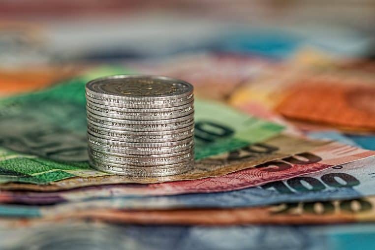 Pièces et billets étalés, illustration du budget mensuel et du pouvoir d’achat.