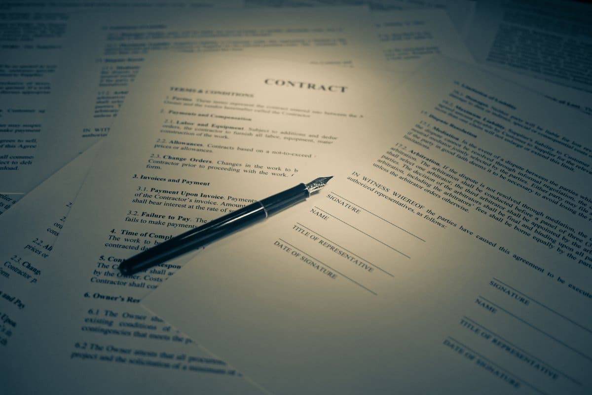 Contrat et stylo, scène de signature sur un document juridique ou bancaire.