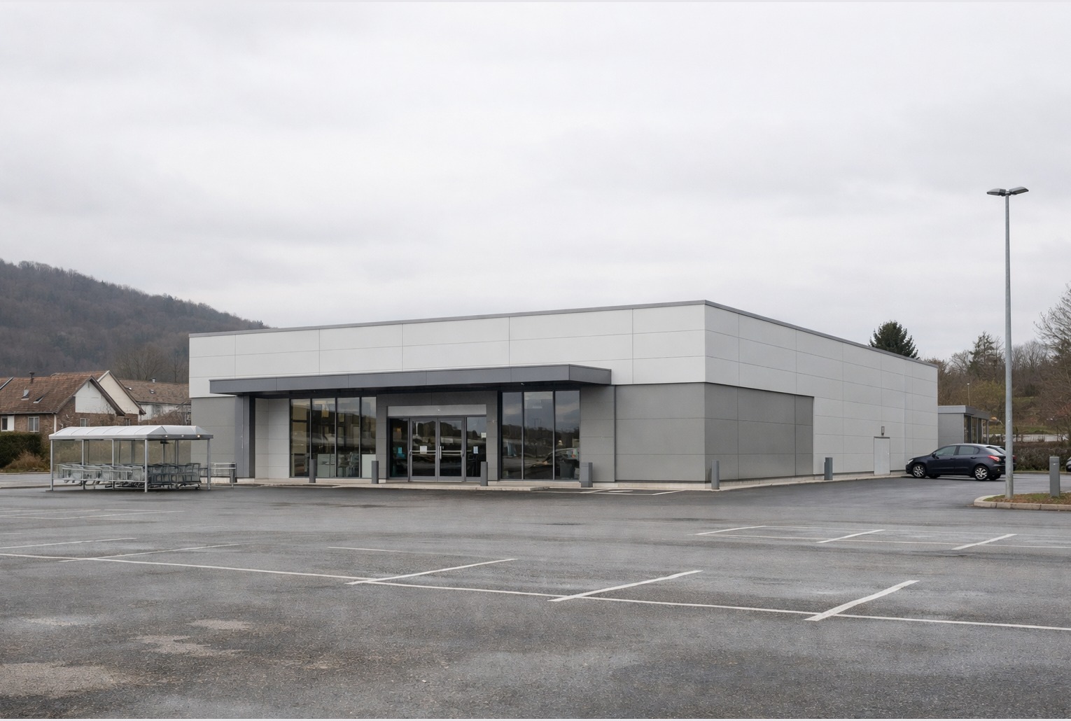 Un supermarché récent, dans un décor urbain sobre, avant une fermeture annoncée.