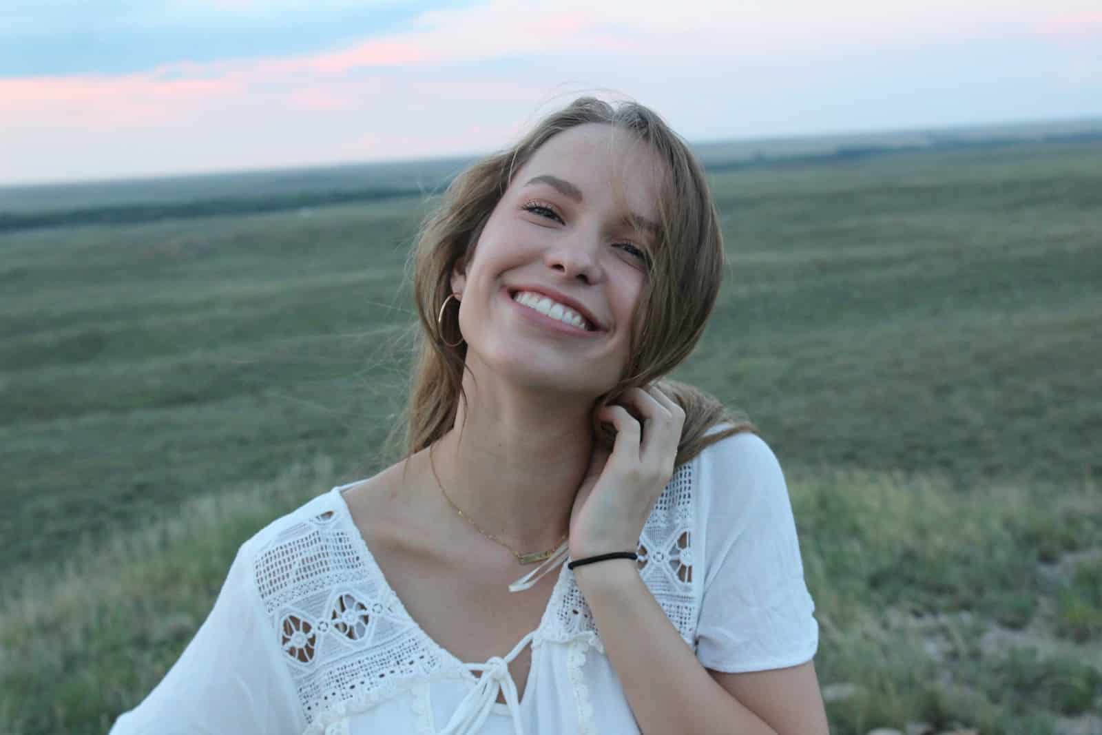 woman smiling while taking photo during daytime