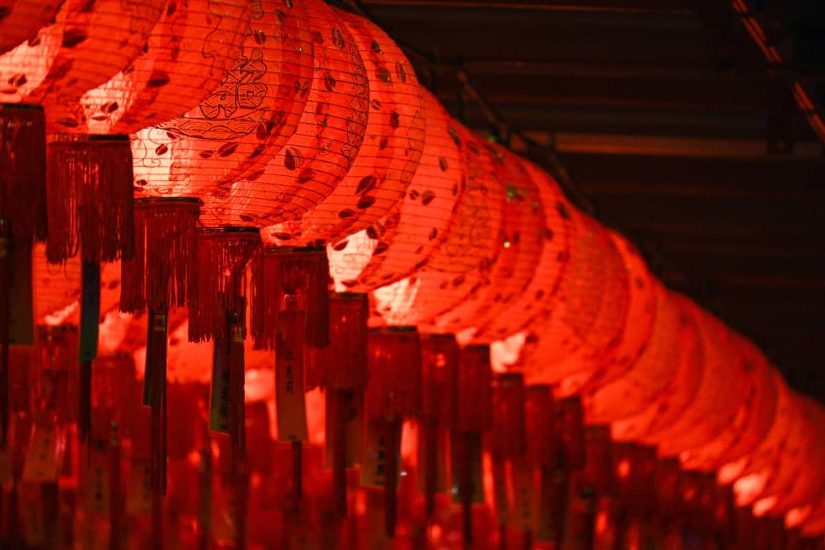 Alignement de lanternes chinoises rouges illuminées la nuit, suspendues dans Chinatown à Singapour.
