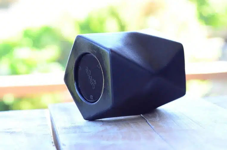Petite enceinte Bluetooth compacte posée sur une table, format nomade idéal pour sonoriser une pièce.