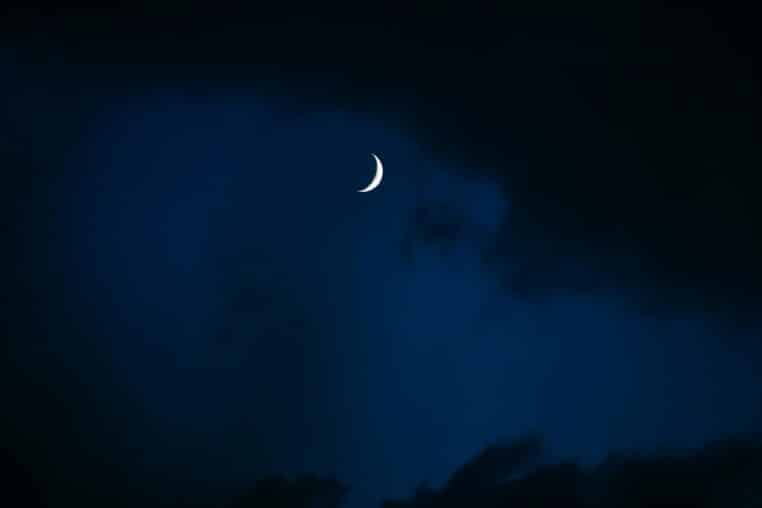 A serene image of a crescent moon glowing in the night sky above Istanbul.