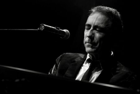 Alain Chamfort en concert (2008), en noir et blanc, devant un micro