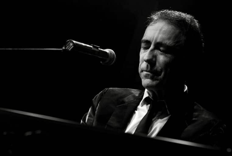 Alain Chamfort en concert (2008), en noir et blanc, devant un micro