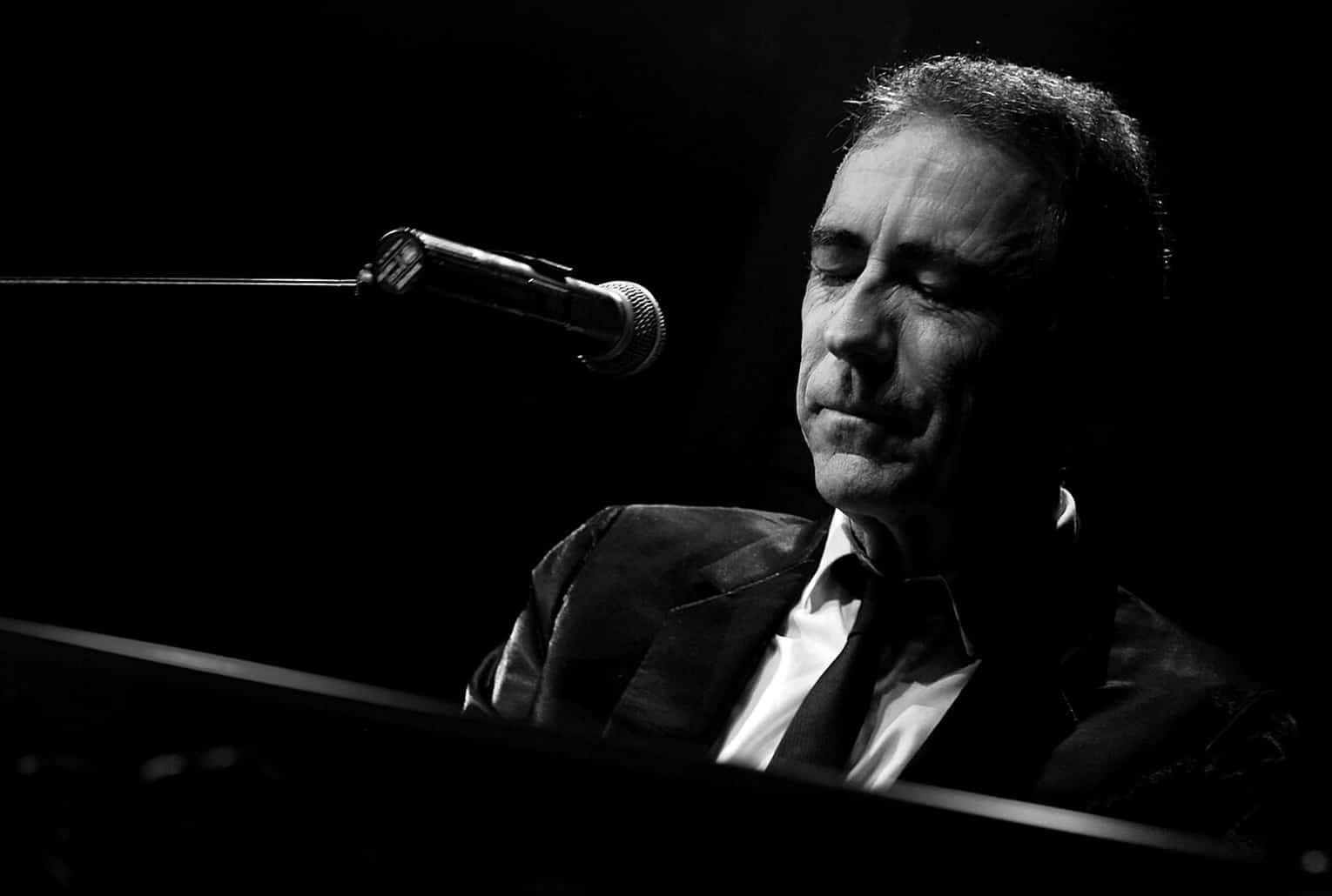 Alain Chamfort en concert (2008), en noir et blanc, devant un micro