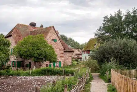 Vue du village de l’Écomusée d’Alsace à Ungersheim, entre maisons traditionnelles et chemin rural