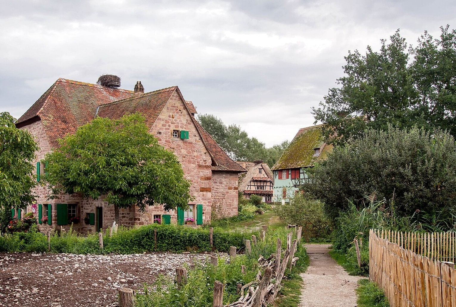 Vue du village de l’Écomusée d’Alsace à Ungersheim, entre maisons traditionnelles et chemin rural