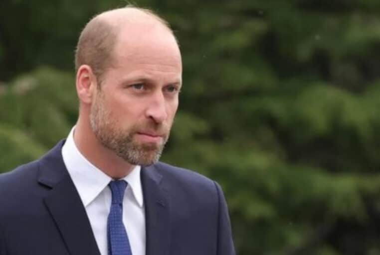 Le prince William, l’air grave, en costume bleu marine lors d’une sortie officielle.