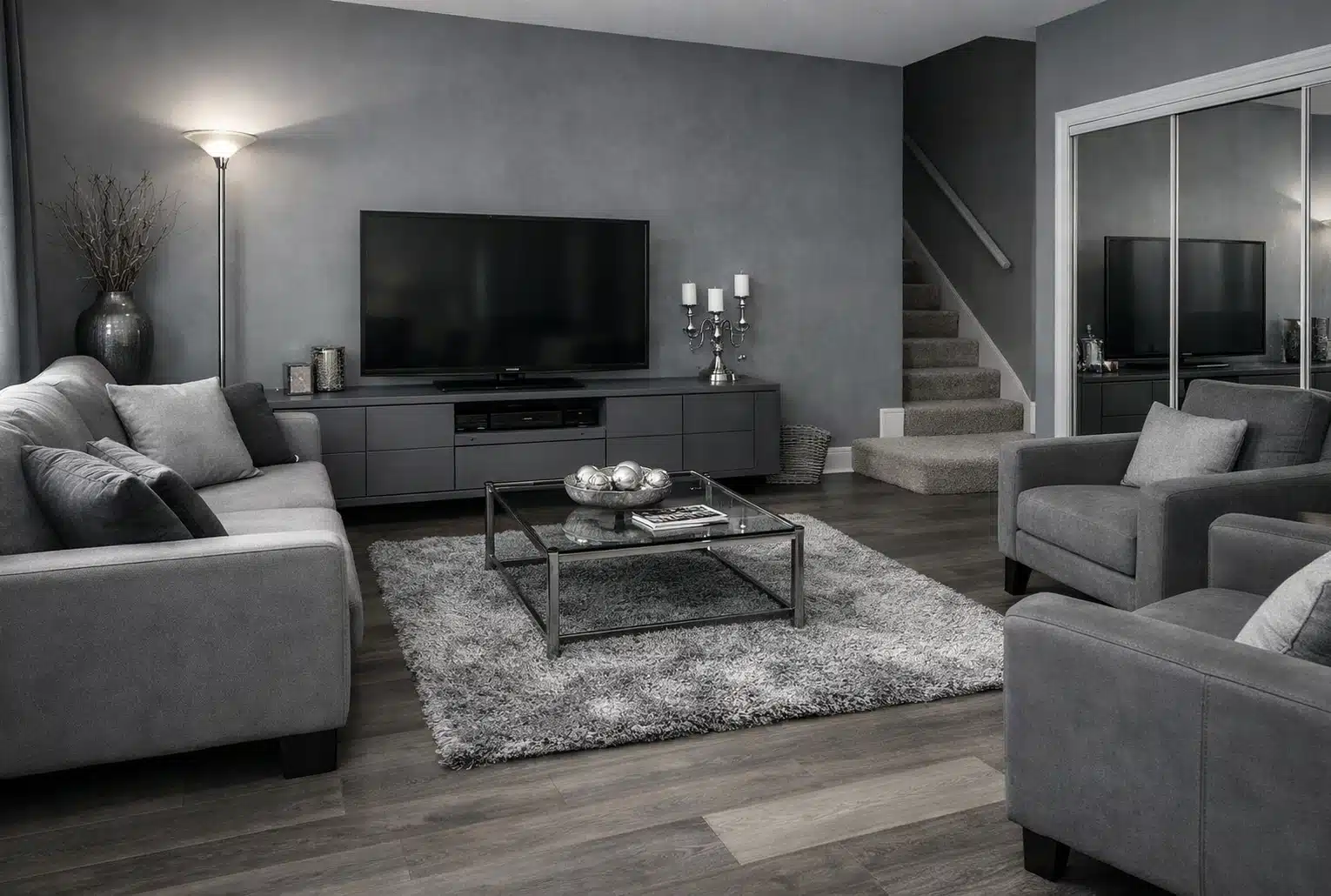 Intérieur ringard : salon tout gris avec tapis trop petit et éclairage halogène dans un coin