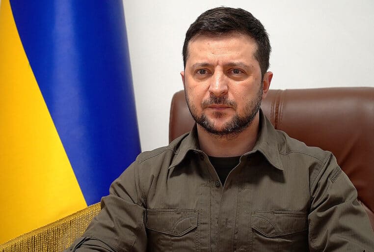 Volodymyr Zelensky s’exprime devant un drapeau ukrainien, pendant la guerre en Ukraine.