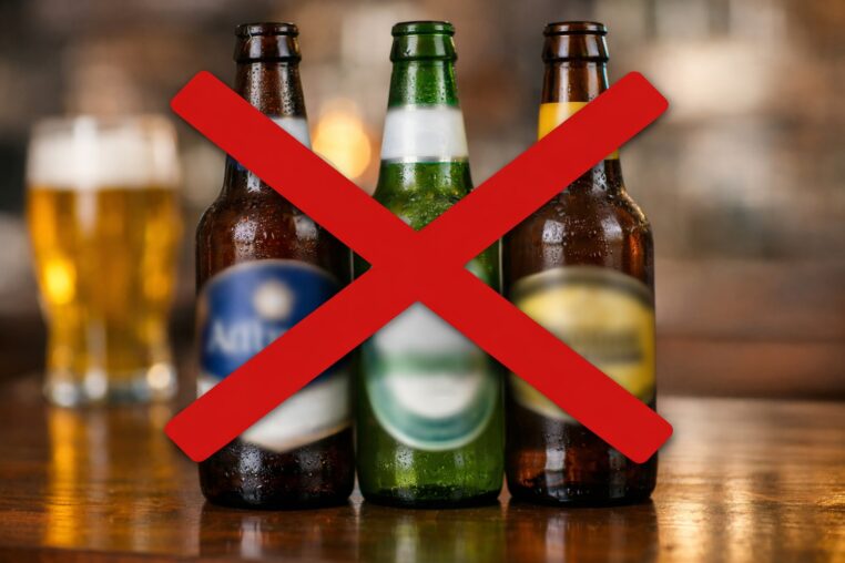 Trois bouteilles de bière aux marques floutées avec une grande croix rouge par-dessus