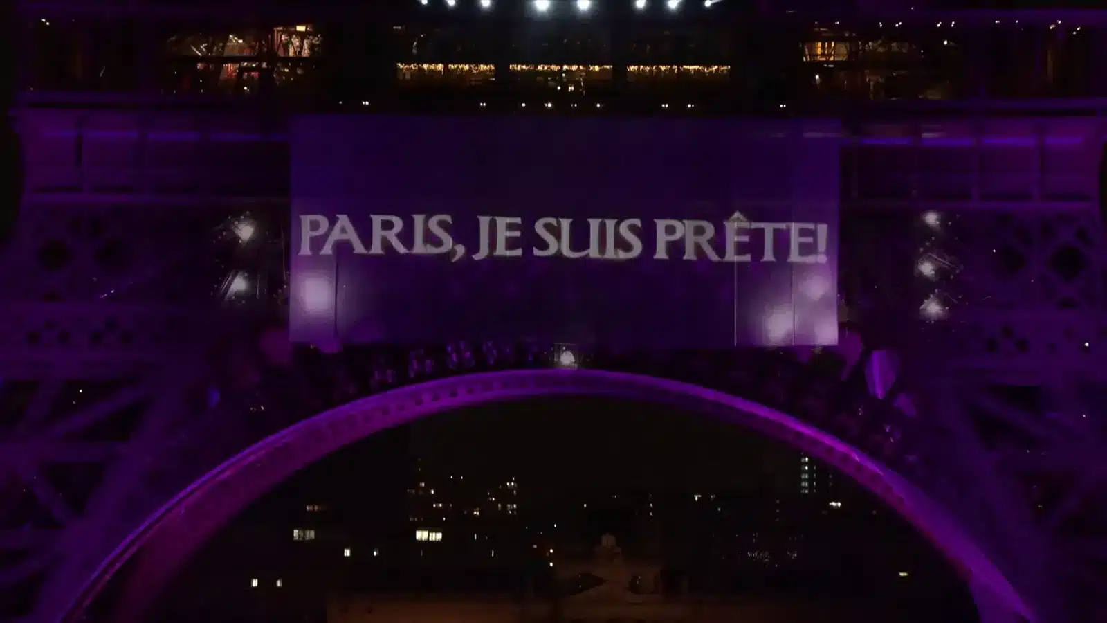 La Tour Eiffel est illuminée en violet avec une bannière affichant "PARIS, JE SUIS PRÊTE!".